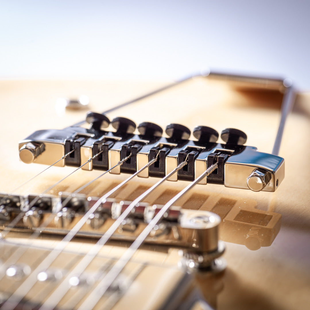 golden colored guitar with nickel tailpiece